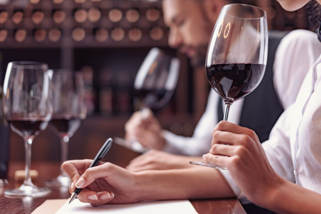 People experiencing the aromas of red wine at a wine tasting.