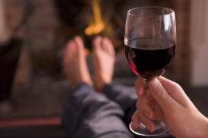 Person holding a glass of red wine.