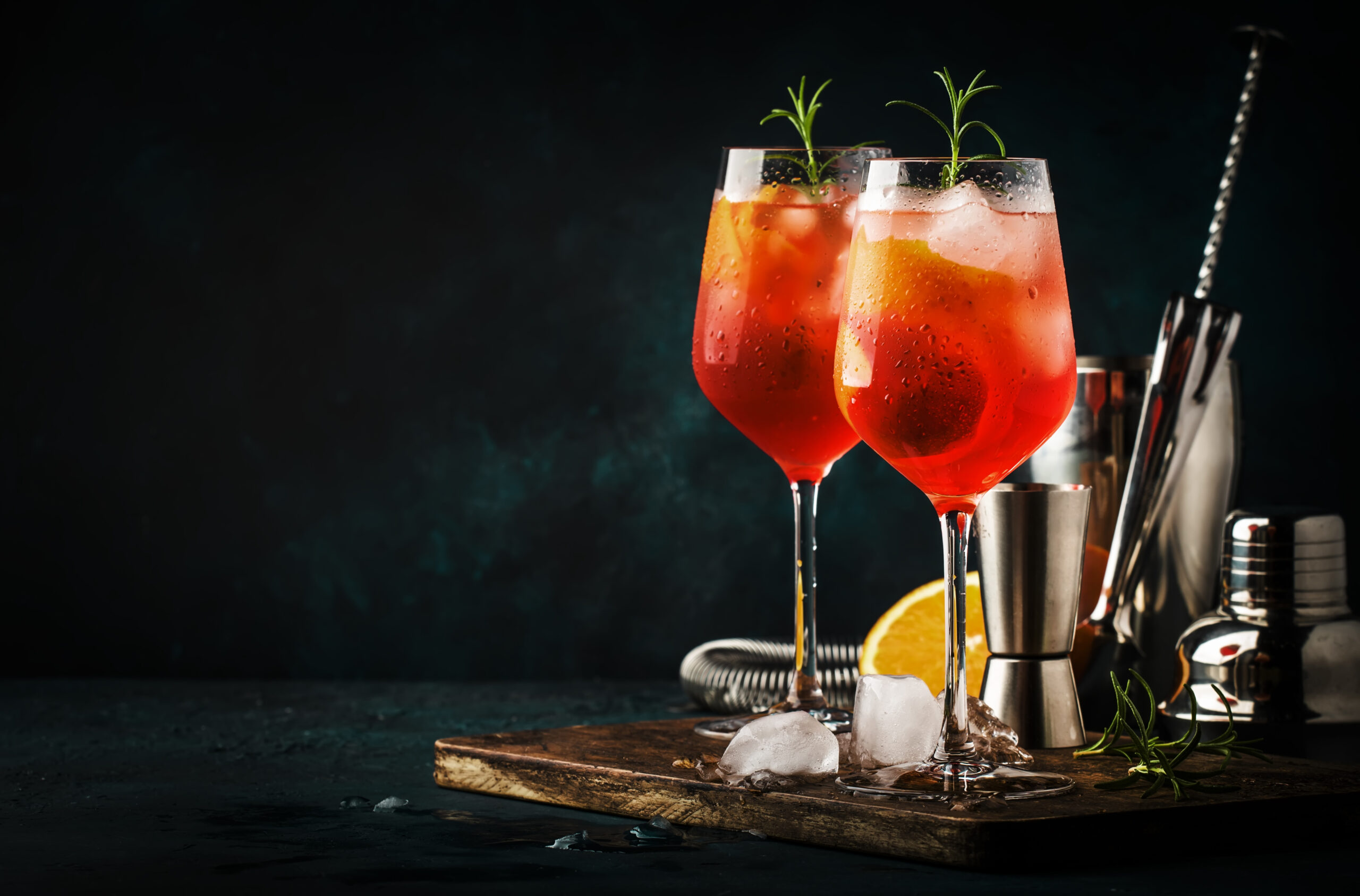 Two wine spritzer cocktails with ice in wine glasses.