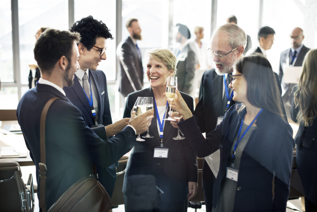 People in business attire in an office toasting with wine.